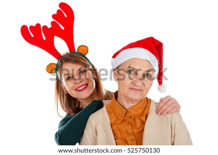 Picture of two happy ladies wearing Christmas costumes on an isolated background