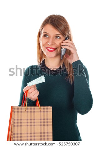 Picture of a happy young woman on the phone while doing Christmas-shopping