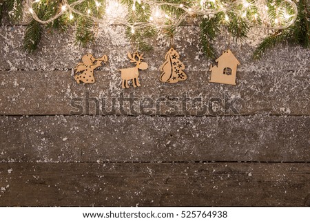 christmas lights and decorations with snow on the wooden background