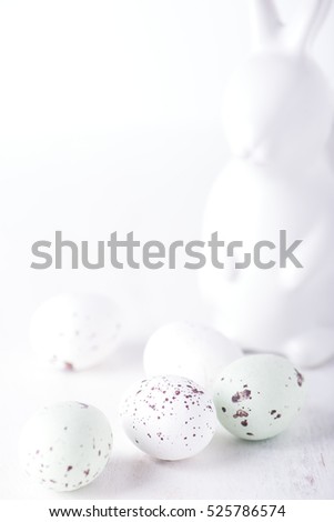 chocolate truffle eggs in white and pastel green colors; and easter bunny egg holder for Easter Day. isolated on white background with copy space, brightly lit, close up and vertical.