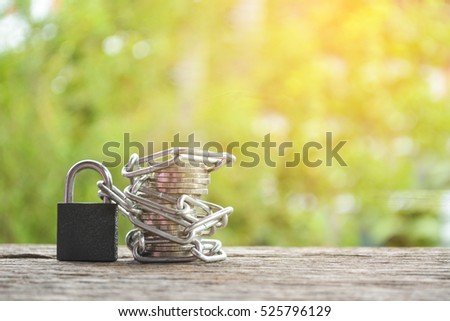 Coin and chain on old wood and tree bokeh background ,concept save money