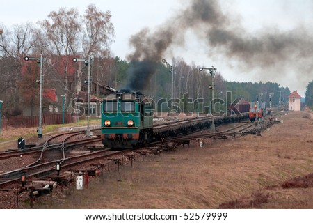 Freight train hauled by the diesel locomotive starting from the station