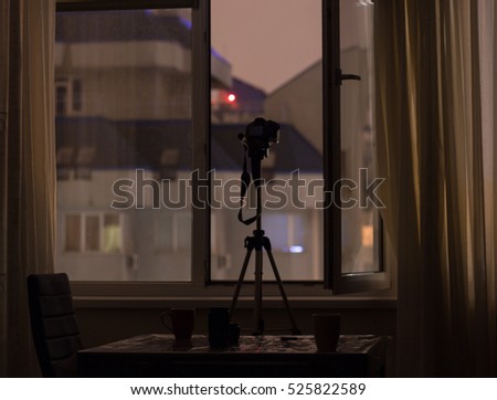 hidden paparazzi camera is shooting target from window  across the street at night