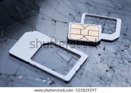 nano sim card extract from sim card adaptor on cracked black screen glass background