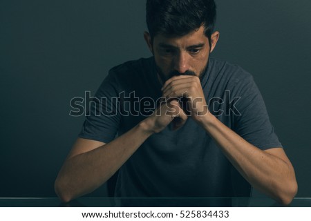 Sad man sitting in dark room. Depression and anxiety disorder concept Royalty-Free Stock Photo #525834433