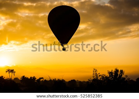 Silhouette of hot air balloon flying over  mountain  and view of  Mist background  in the morning sunrise time