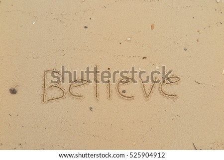 written words "Believe" on sand of beach