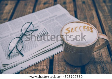 Cup of coffee with wording " success"  and glasses on  Business newspaper