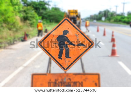 Construction sign on country road with trees on roadside background - Roadworks Ahead. Signs warning of roadworks,safety first.