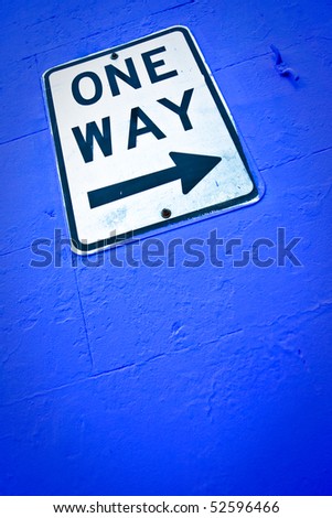 one way sign on blue wall