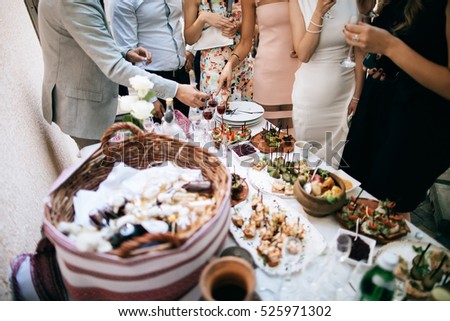 friends drink alcohol and eat snacks and talk at the celebration of the wedding Royalty-Free Stock Photo #525971302