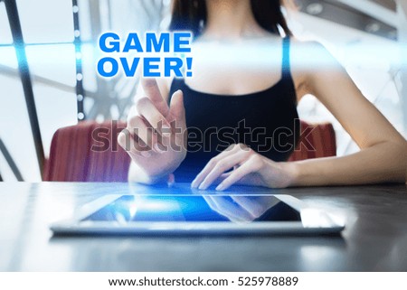 Woman is using tablet pc, pressing on virtual screen and selecting game over!.
