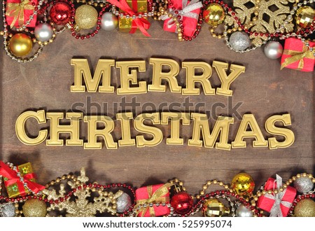 Merry christmas golden text and Christmas decorations on a wooden background 