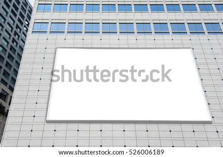 Blank advertising billboard in metallic frame with spotlight on modern office building or outside department store building in the city, useful for advertisement