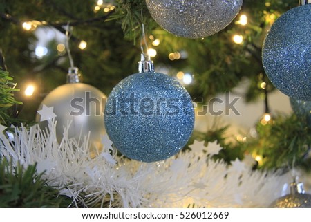 Blue and silver Christmas or Xmas ball ornaments hanging on Christmas or pine tree branch in theme frozen.
