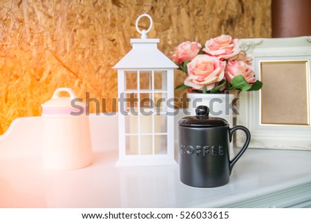 Coffee mugs, vases, picture frames white, lamps  vintage style on the table white on wood background.