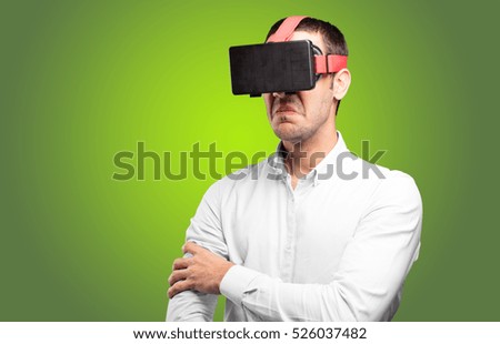 Young man using a virtual glasses against green background