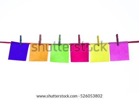 Colorful paper cards hang on rope by wooden peg isolated on white