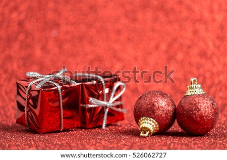 Small red christmas toys on red glitter background. Merry Christmas and Happy New Year card