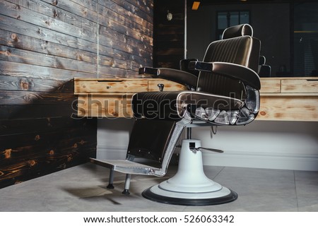 Stylish Vintage Barber Chair In Wooden Interior. Barbershop Theme Royalty-Free Stock Photo #526063342