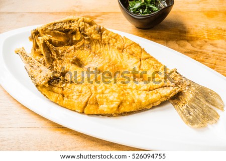 Fried sea bass fish in white plate with spicy and sweet sauce in Thai style - Processing Warm white balance