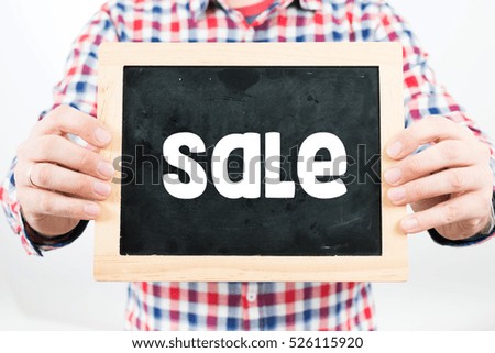 Sale. Man holding small blackboard.