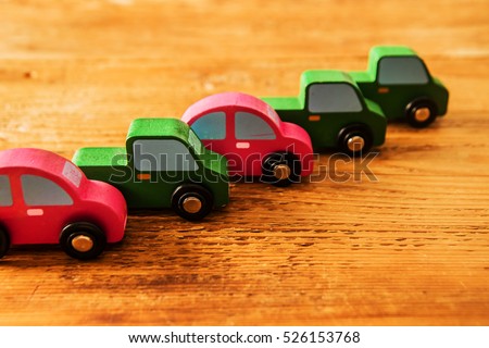 a lot, many wooden car toys stand in perspective line on wooden area. empty copy space for inscription or other objects . Eco, bio fuel sign, symbol and idea