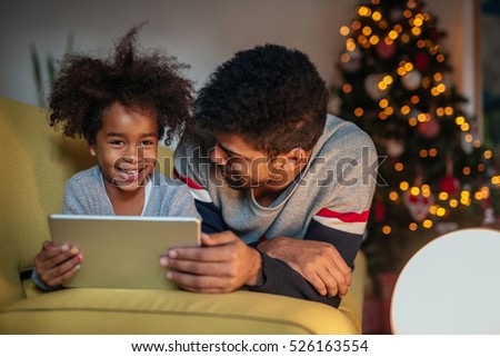 Dad and daughter using tablet and having fun together.