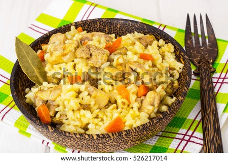 Rice with carrots, chicken and spices. Studio Photo
