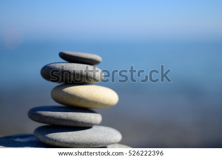Zen spa stones with blue water and sky. Balanced stones background with copy space. Spa symbol. Beautiful picture. Symbol of stability. Stones pile background.