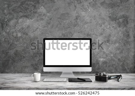 White screen computer in room on gray table and camera film, workplace with cement wall