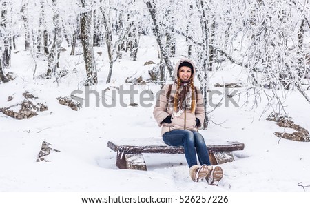 Winter portrait of a yong girl at the snow forest. Snow lanscape at the top of a mountain