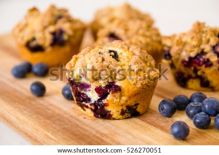 freshly baked blueberry muffins with an oat crumble topping on a natural wooden board Royalty-Free Stock Photo #526270051