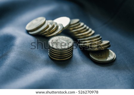 Mixed stack of european coins on a blue silk background