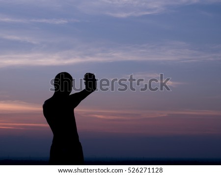 Silhouette of a man taking a picture in twilight time
