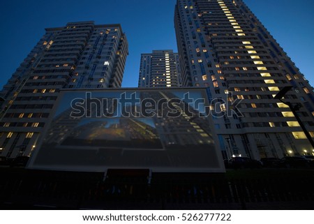 Translaion picture onto the big screen from notebook in the yard of a residential complex.