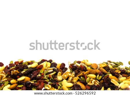 Close-up top view mix different of nuts and dried fruits isolated on white. Organic healthy trail mix snacks. Variety almond, walnut, cashew, raisin, goji, dried cranberries, pumpkin, sunflower seeds.