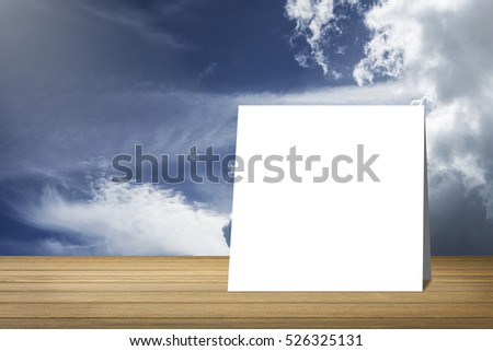 White card out on wooden desk or wooden floor on blue sky and cloud background.use for present or mock up your product.clipping path include