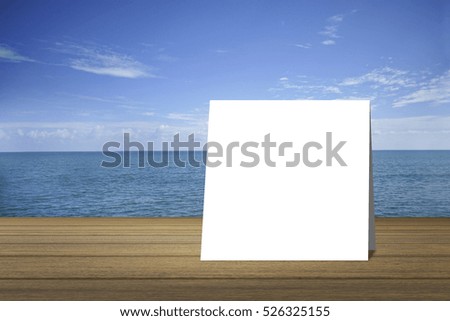white card put on  wood table and beautiful peace sea in background. product display template. Business presentation.clipping path include