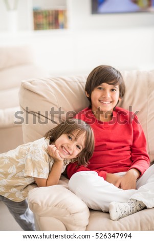 Child inside interior of modern home sitting on sofa