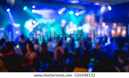 Blur image of a crowd of people at a concert live show on stage.vintage tone, blur background concept.