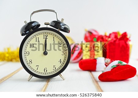 New Year's clock. Decorated with gift box and Christmas decorations background. Celebration Concept for New Year celebration.