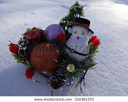 Christmas composition with snowman toy on the background of sparkling snow