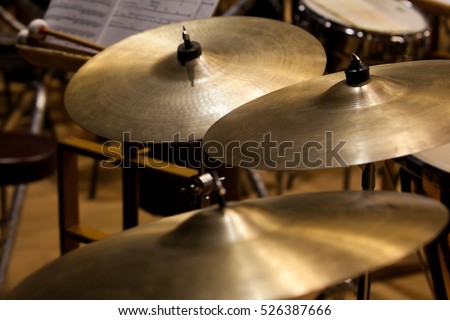 Orchestral cymbals closeup in dark colors Royalty-Free Stock Photo #526387666