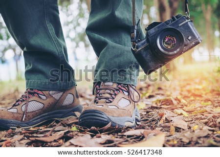 Feet Traveler man and retro photo camera outdoor Travel Lifestyle vacations and travel concept vintage tone