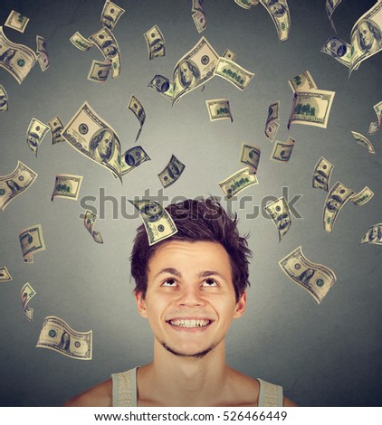 Happy man under money rain falling down dollar bills banknotes. Financial freedom concept