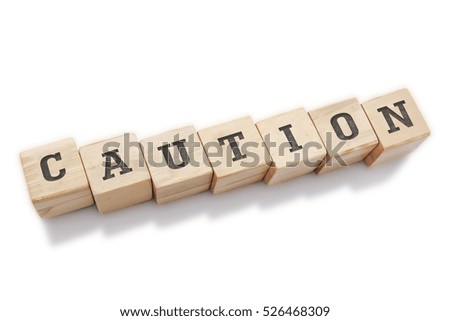CAUTION word made with building blocks isolated on white