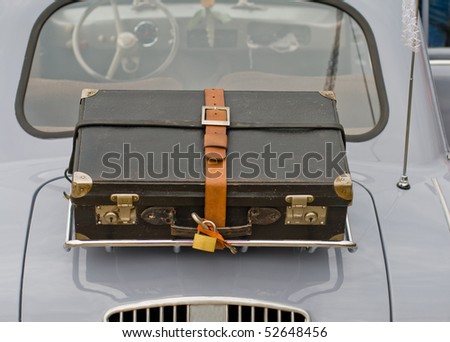 An old suitcase on the back of an old car Royalty-Free Stock Photo #52648456