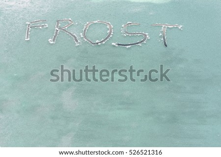 Iced frosted window, frost on glass, ice in winter, texture with text