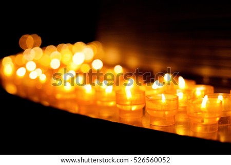Church candles in transparent chandeliers